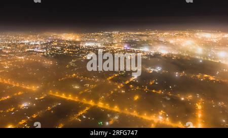paysage de la ville de bokeh léger au ciel nocturne avec de nombreuses étoiles, ville floue par brouillard couvert Banque D'Images