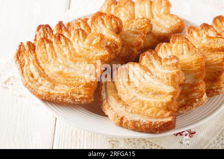 Biscuits palmiers pâte feuilletée sucrée closeup sur l'assiette sur la table. Horizontal Banque D'Images