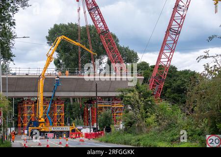 Harefield, Royaume-Uni. 3 août 2023. La construction par Align JV se poursuit sur le viaduc HS2 à grande vitesse de Colne Valley. Moorhall Road (photo) à Harefield, dans le quartier londonien de Hillingdon, est actuellement fermé à la circulation car des structures de soutènement temporaires sont mises en place à travers la route sous des segments de viaduc qui sont assemblés par une grue sur chenilles. Le viaduc de Colne Valley traversera Moorhall Road entre les lacs Korda et Savay, juste au sud du canal Grand Union. L'Infrastructure and Projects Authority, a placé le projet HS2 de plusieurs milliards de livres entre Londres an Banque D'Images