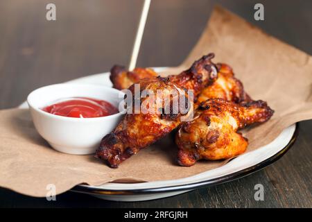 les ailes sont cuites et prêtes à manger dans un café, des ailes de poulet cuites au four avec du ketchup Banque D'Images