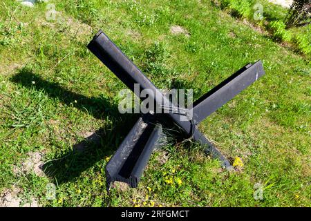 fortifications métalliques anti-char et hérissons sur herbe verte, morceaux de rails soudés ensemble pour contrer les chars ennemis et les véhicules dans la guerre Banque D'Images