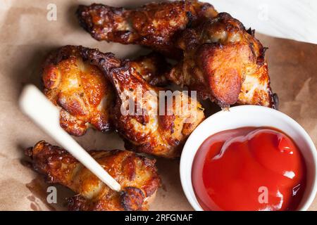 ailes de poulet cuites avec ketchup, les ailes sont cuites et prêtes à manger dans un café Banque D'Images