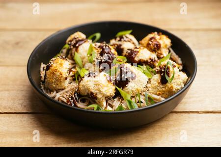 Fait maison végétalien chou-fleur croustillant Teriyaki sur des nouilles. Banque D'Images