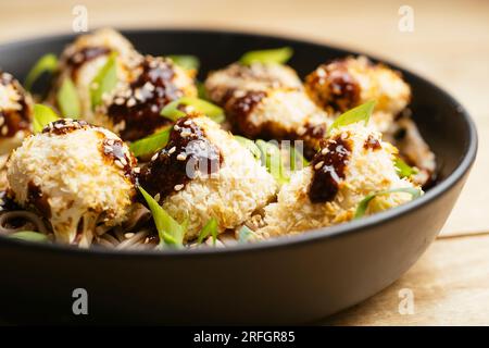 Fait maison végétalien chou-fleur croustillant Teriyaki sur des nouilles. Banque D'Images