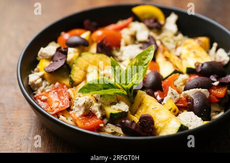 Plat fait maison avec des légumes d'été grillés avec des olives noires et feta végétalienne sur pesto orzo. Banque D'Images