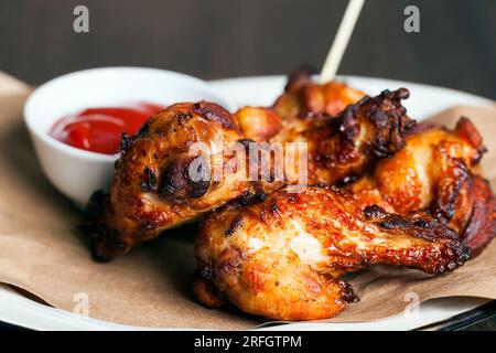 ailes de poulet cuites au four avec ketchup, les ailes sont cuites et prêtes à manger dans un café Banque D'Images