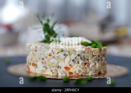 Une salade russe traditionnelle olivier faite de saucisses cuites, de pois verts marinés, d'œufs, de mayonnaise et de concombres marinés Banque D'Images