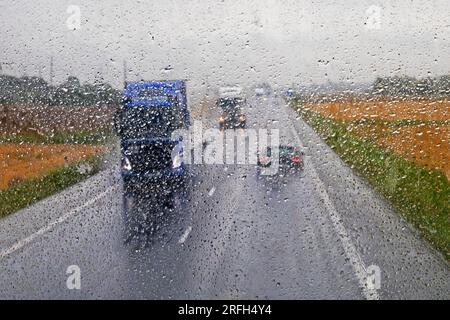 les camions roulent le long de la route principale glissante pendant la pluie. Mauvais temps. Mauvaise visibilité Banque D'Images