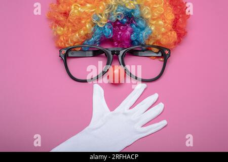 Funny Party concept visage surpris formé avec des gants. Rainbow Clown Wig Set avec lunettes et nez de clown rouge comme un visage, Fluffy afro synthétique Cospl Banque D'Images