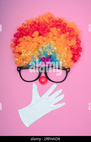 Funny Party concept visage surpris formé avec des gants. Rainbow Clown Wig Set avec lunettes et nez de clown rouge comme un visage, Fluffy afro synthétique Cospl Banque D'Images