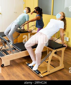 Adolescents dans les masques d'entraînement pilates dans la salle de gym avec traine Banque D'Images