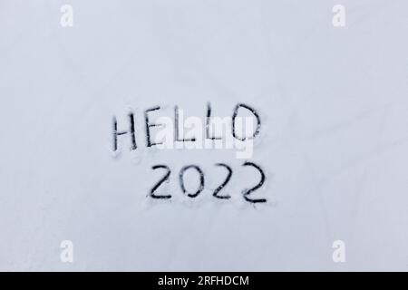 les chiffres et le mot bonjour est dessiné sur la neige dans la saison d'hiver, l'inscription sur la nouvelle année 2022 Banque D'Images