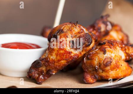 les ailes sont cuites et prêtes à manger dans un café, des ailes de poulet cuites au four avec du ketchup Banque D'Images