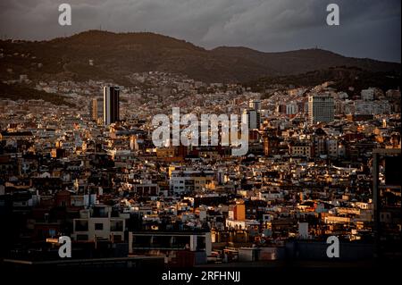 Vue aérienne de la ville de Barcelone avec des toits urbains denses et les collines environnantes sous un ciel nuageux. Banque D'Images