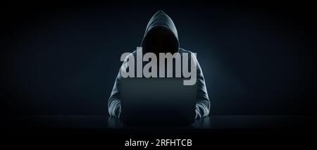 Homme anonyme dans le capot utilisant un ordinateur portable sur fond noir. Conception de bannière Banque D'Images