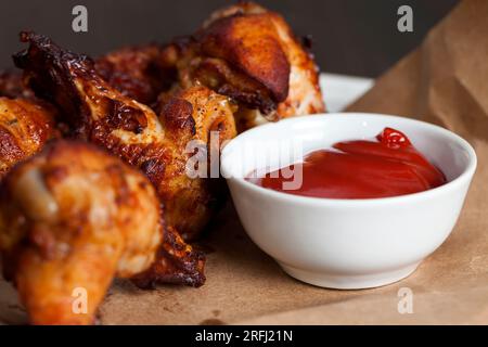 ailes de poulet cuites au four avec ketchup, les ailes sont cuites et prêtes à manger dans un café Banque D'Images