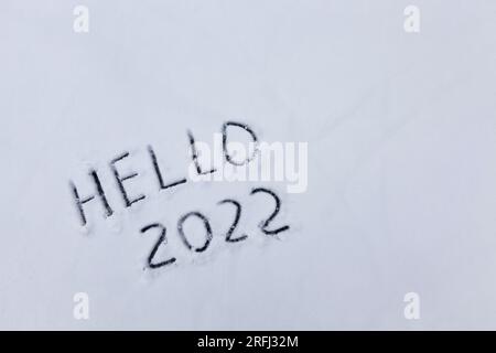 l'inscription sur la nouvelle année 2022, les chiffres et le mot bonjour est dessiné sur la neige dans la saison d'hiver Banque D'Images