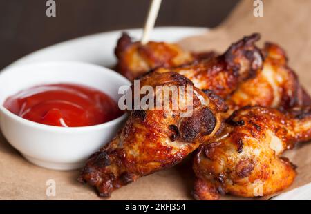 ailes de poulet cuites avec ketchup, les ailes sont cuites et prêtes à manger dans un café Banque D'Images