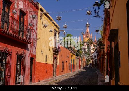 Des étoiles mexicaines en étain se sont accrochées à travers la Calle Aldama pavée avec le clocher de la Parroquia rose de San Miguel Arcangel dominant au-dessus du centre-ville historique de San Miguel de Allende, au Mexique. Banque D'Images