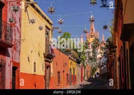 Des étoiles mexicaines en étain se sont accrochées à travers la Calle Aldama pavée avec le clocher de la Parroquia rose de San Miguel Arcangel dominant au-dessus du centre-ville historique de San Miguel de Allende, au Mexique. Banque D'Images