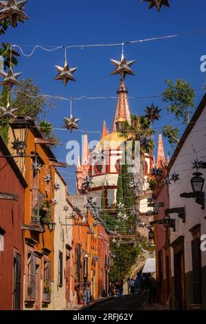 Des étoiles mexicaines en étain se sont accrochées à travers la Calle Aldama pavée avec le clocher de la Parroquia rose de San Miguel Arcangel dominant au-dessus du centre-ville historique de San Miguel de Allende, au Mexique. Banque D'Images