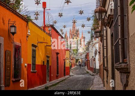 Des étoiles mexicaines en étain se sont accrochées à travers la Calle Aldama pavée avec le clocher de la Parroquia rose de San Miguel Arcangel dominant au-dessus du centre-ville historique de San Miguel de Allende, au Mexique. Banque D'Images