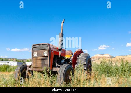Tracteur massey ferguson rouge vintage dans le champ à Tropic Utah Banque D'Images