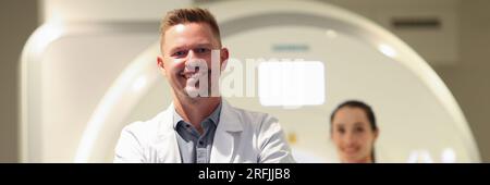 Un médecin en gros plan souriant et une patiente et un scanner CT en arrière-plan. Banque D'Images