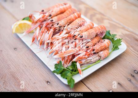 écrevisses bouillies en pot, prêtes à manger, sur une assiette sur une table en bois, fruits de mer très savoureux et aphrodisiaques Banque D'Images