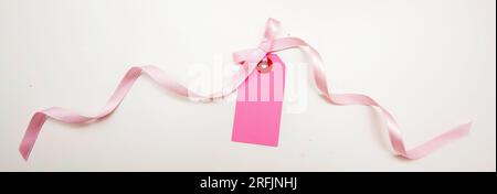 Étiquette de prix rose vierge isolé sur fond blanc. Carte-cadeau vide de couleur pastel et noeud de ruban bouclé, espace de copie, Banque D'Images