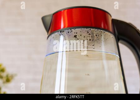 bouilloire électrique avec eau bouillante et condensat sur les parois en verre. Accessoires de cuisine modernes Banque D'Images