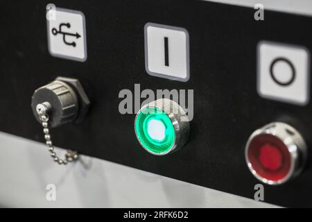 Panneau de commande industriel avec boutons marche/arrêt et prise USB fermée, gros plan photo avec mise au point sélective Banque D'Images