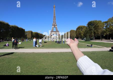 Tour Eiffel, Paris. Main des femmes pointant vers la Tour Eiffel. Image capturée depuis le parc du champ des Mars à Paris, France. Banque D'Images