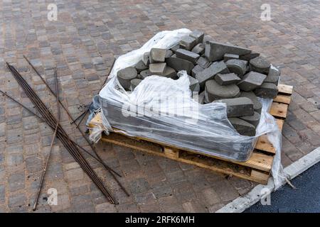 les morceaux restants de dalles de pavage sur une palette en bois après l'achèvement des travaux sur l'amélioration de la ville Banque D'Images