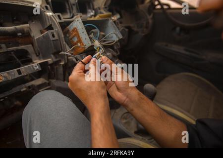 gros plan d'un mécanicien réparant l'appareil électrique d'une voiture Banque D'Images