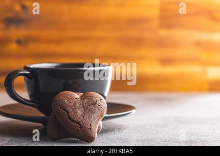 Biscuits en forme de coeur et tasse à café sur la table de la cuisine. Banque D'Images