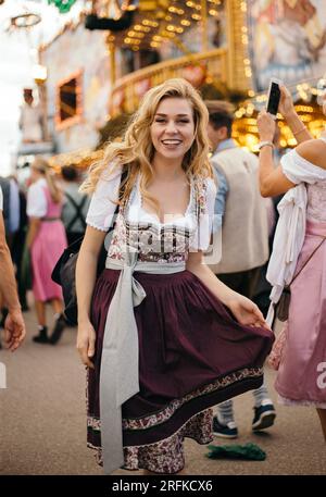 Jeune femme heureuse portant la robe bavaroise dirndl Banque D'Images