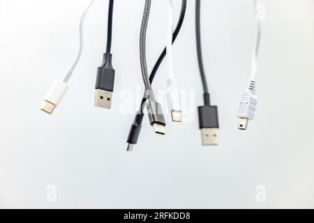 Divers câbles et connecteurs USB noir et blanc de type A et de type C recadrés en studio sur fond blanc Banque D'Images