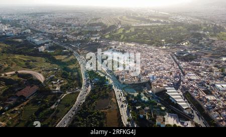 Vue aérienne drone de Fès au coucher du soleil, Maroc. Plusieurs bâtiments résidentiels faits dans le style national, verdure, autoroute avec des voitures Banque D'Images