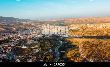 Vue aérienne drone de Fès au coucher du soleil, Maroc. Plusieurs bâtiments résidentiels faits dans le style national, collines rocheuses autour Banque D'Images