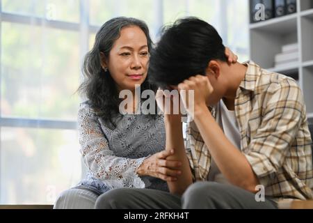 Mère aimante d'âge moyen consolant son fils qui pleure. Concept de soutien, de soins, de confiance et de sympathie. Banque D'Images