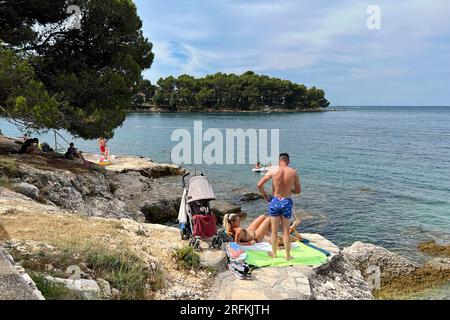 Porec, Kroatien. 01 août 2023. Plava Laguna, côte Adriatique près de Porec/Croatie, plage. Les vacanciers sont sur la plage de pierre, plage rocheuse au soleil et se détendre, se détendre. ? Crédit : dpa/Alamy Live News Banque D'Images