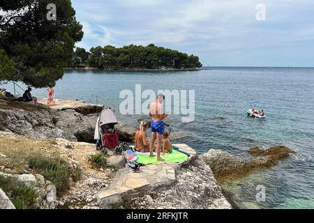 Porec, Kroatien. 01 août 2023. Plava Laguna, côte Adriatique près de Porec/Croatie, plage. Les vacanciers sont sur la plage de pierre, plage rocheuse au soleil et se détendre, se détendre. ? Crédit : dpa/Alamy Live News Banque D'Images