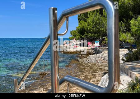 Porec, Kroatien. 02 août 2023. Plava Laguna, côte Adriatique près de Porec/Croatie, plage. Les vacanciers sont sur la plage de pierre, plage rocheuse au soleil et se détendre, se détendre. ? Crédit : dpa/Alamy Live News Banque D'Images