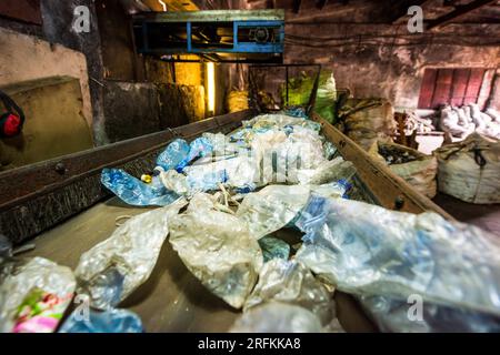 Déchets plastiques sur un tapis roulant dans une usine de recyclage des déchets Banque D'Images