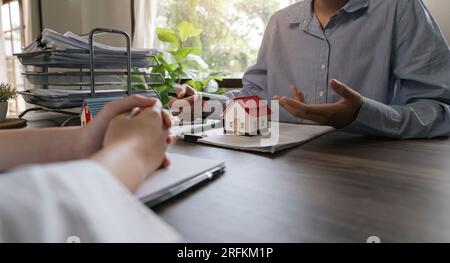 Agents immobiliers maisons dans le projet pour expliquer en détail aux clients. Expliquer et présenter des informations sur les achats de maisons et de prêts hypothécaires. réel Banque D'Images