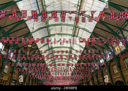 Londres, Angleterre, Royaume-Uni - 7 mai 2023. Des milliers de drapeaux britanniques Union Jack en bandoulière, drapeaux britanniques au marché de Covent Garden pour le couronnement du roi Charles III. Banque D'Images