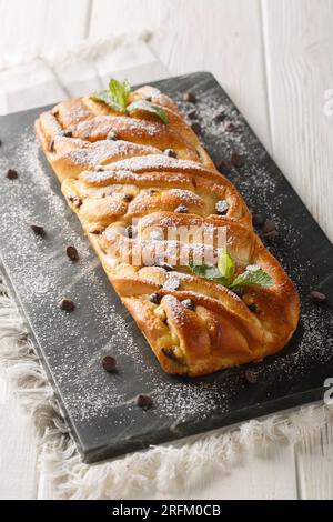 Tresse au chocolat et tarte à la crème Treccia pour le gros plan du matin de Pâques sur la planche d'ardoise sur la table. Vertical Banque D'Images