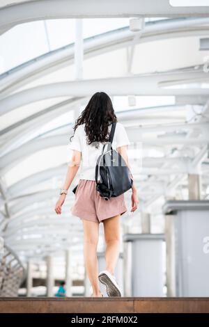 Une jeune fille thaïlandaise fait son chemin à travers la station de train aérien de Chong Nonsi BTS à Bangkok en Thaïlande. Banque D'Images