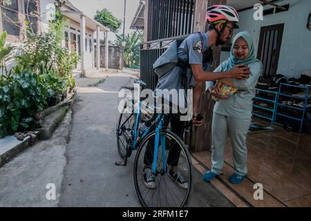 Bogor, Indonésie - 01 août 2023 : mari disant au revoir à sa femme et à son bébé pour aller travailler à Bogor, Java Ouest. Banque D'Images